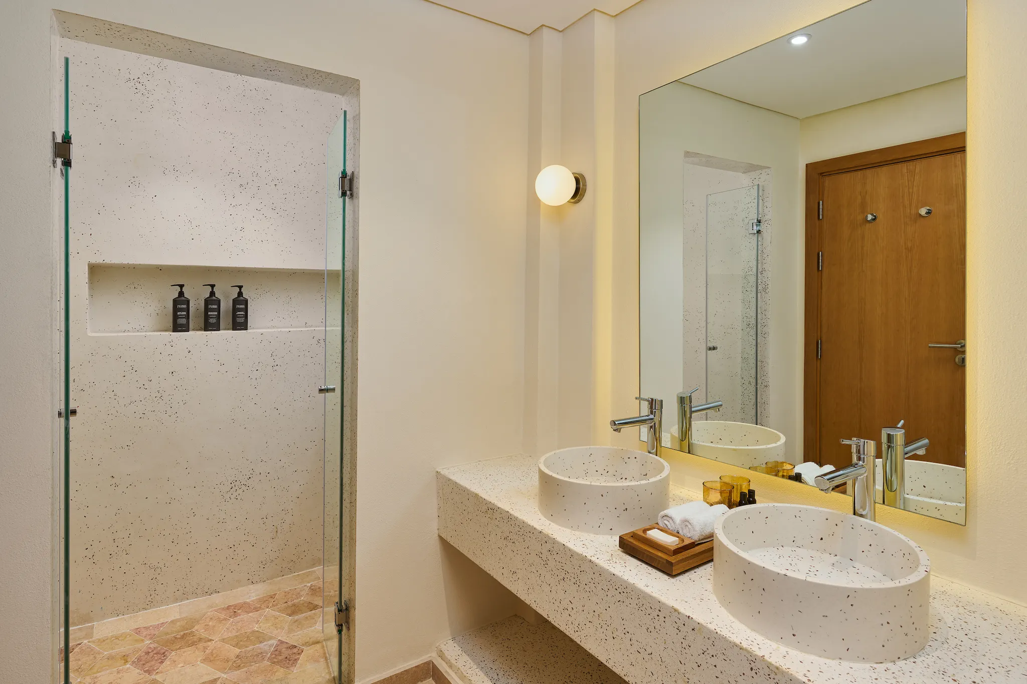 Modern Superior Suite bathroom with double stone vessel sinks, large illuminated mirror, and glass shower enclosure at Sheraton Miramar Resort El Gouna