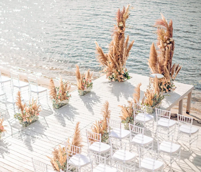 Scenic beach wedding setup at Chedi El Gouna, featuring rows of white chairs arranged on the sandy shore with a view of the ocean.