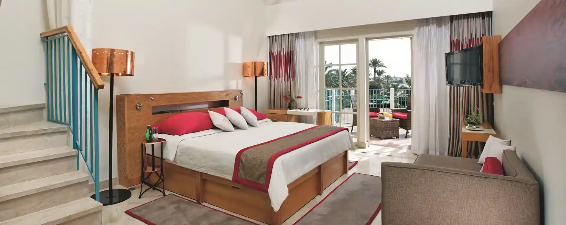 A hotel room with a king-size bed, neatly made, and the curtains open to reveal a scenic view outside.