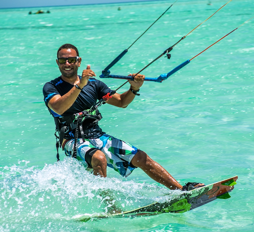 Man smiling to the camera as he kitesurfs on the Gouna red sea