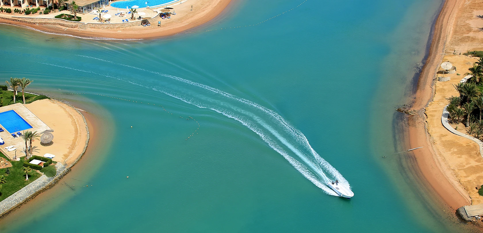 Top view of a lagoon with a boat cruising through the water.