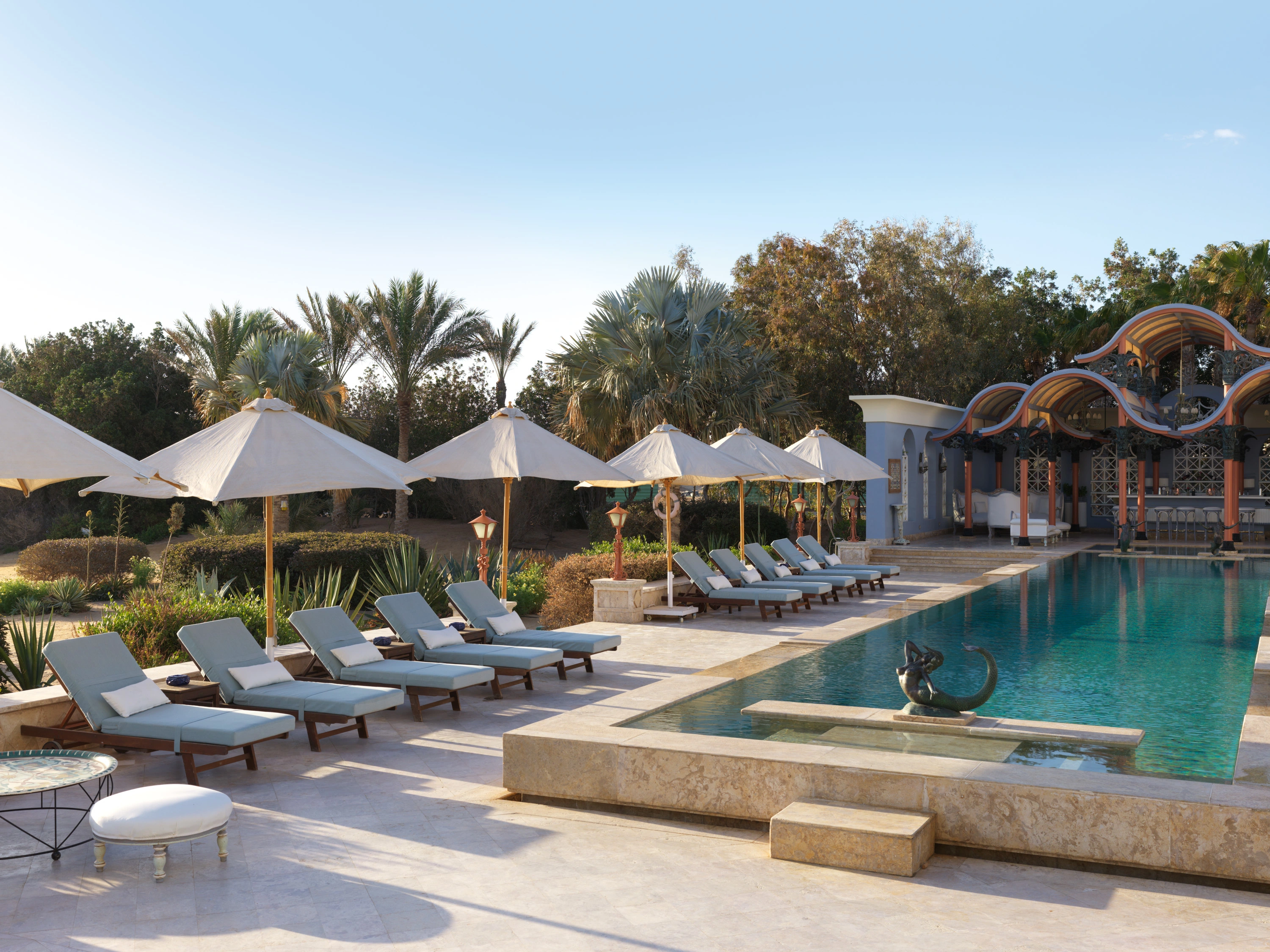 The pool area at La Maison Bleue el Gouna, featuring stylish umbrellas and comfortable lounges for guests to relax and enjoy.