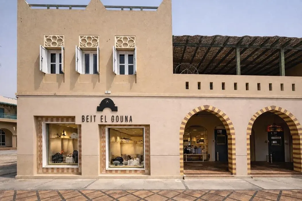 The sand-coloured façade of Beit El Gouna Store with striped arched doorways