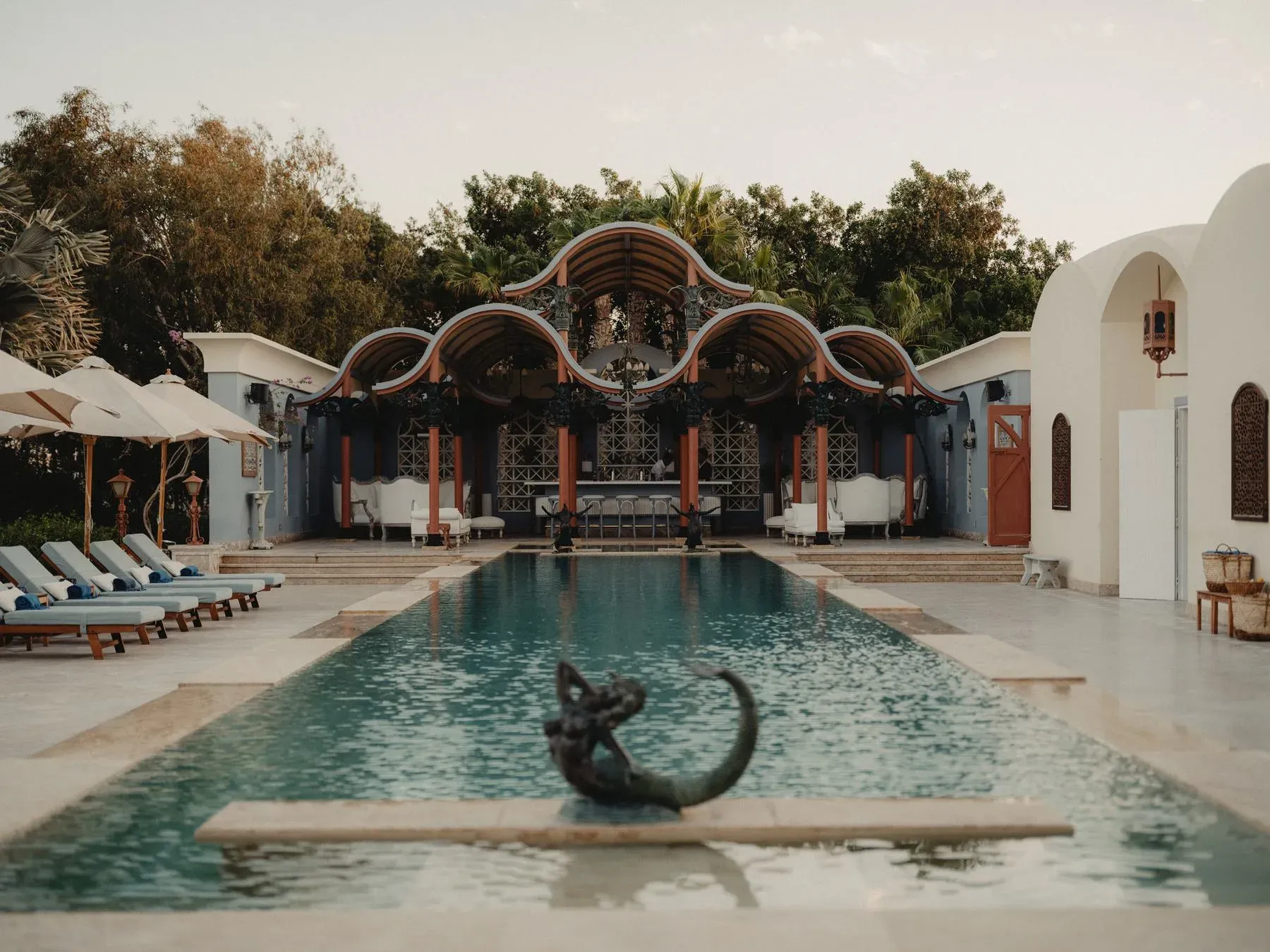 La Maison Bleue in El Gouna: a long turquoise pool leading to a pavilion of scalloped arches