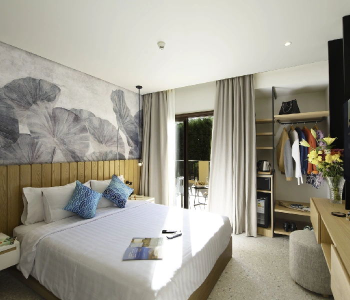 Elegant hotel room at night featuring a king-size bed, and open balcony curtains that allow a glimpse of the nighttime ambiance outside. The interior is beautifully decorated with stylish furnishings and soft lighting, creating a cozy and sophisticated atmosphere.