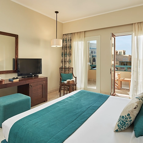 Hotel room featuring a king-sized bed and open curtains, inviting natural light into the serene space.