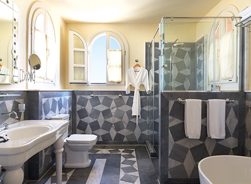 The Tower Suite at La Maison Bleue, offering a grand and luxurious space. The suite features a spacious layout with a king-size bed, a separate living area, and an opulent bathroom. Large windows or a private balcony provide stunning panoramic views of the surrounding area. The decor is elegant and modern, with high-end finishes and stylish furnishings, creating a sophisticated and comfortable retreat.