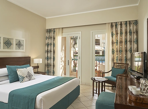 King bedroom at Red Sea, Egypt, featuring a luxurious king-sized bed with soft linens, stylish decor, and modern furnishings. The room is well-lit and designed for comfort, providing a relaxing and elegant space for guests to unwind.