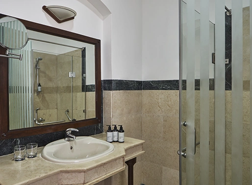 Bathroom at Sultan Bey El Gouna Red Sea, Egypt, featuring a modern design with a sleek vanity, large mirror, and elegant tile work. The space includes contemporary fixtures and ample lighting, creating a clean and luxurious environment for guests.
