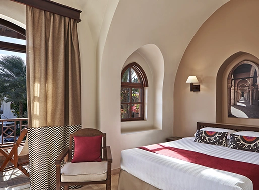 King bedroom with a garden view at Red Sea, Egypt, featuring a spacious king-sized bed with plush linens, stylish decor, and large windows that open to a beautiful garden. The room is designed for comfort and relaxation, offering a serene and inviting atmosphere.