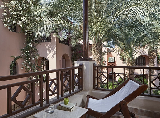 Terrace with a garden view, featuring a comfortable lounge area. The space includes stylish outdoor seating, such as a plush sofa or chairs, with a table, and is surrounded by lush greenery. The terrace offers a relaxing spot to enjoy the garden view and outdoor ambiance.