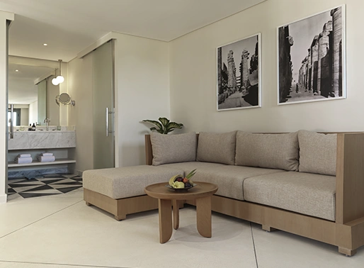 Living area of the Junior Seaview Suite at Gouna Red Sea, featuring a comfortable sofa set, coffee table, and stylish decor. The space is bright and airy, with large windows offering beautiful views of the Red Sea. The room is designed for relaxation and includes modern furnishings and elegant touches.