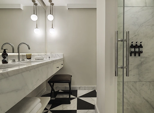Bathroom of the Superior Sea View Twin Room at Gouna Red Sea, showcasing a modern and clean design with a spacious shower area, contemporary fixtures, and elegant tile work. The bathroom features a large mirror, vanity sink, and ample space for guest convenience.